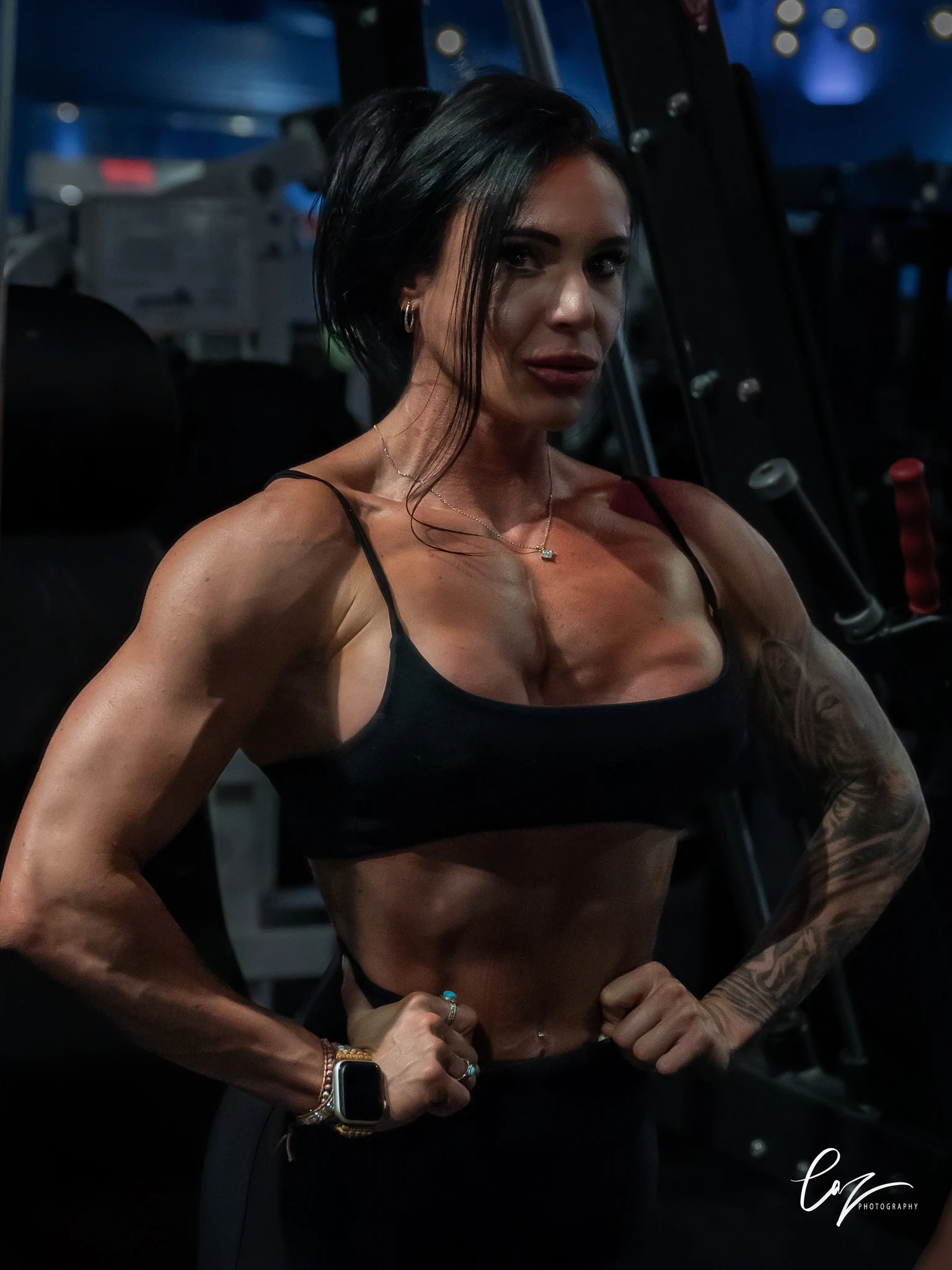 Fitness coach posing in a dark weight room